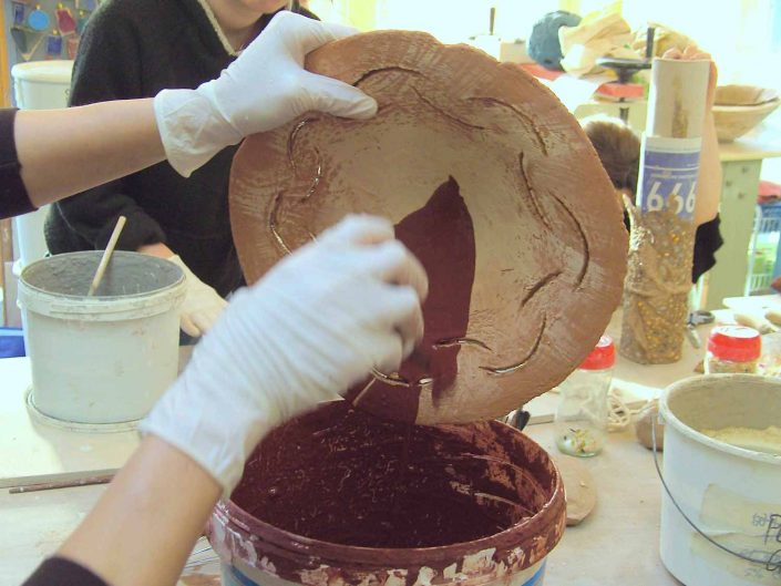 Student glazing a hand-built bowl. Safety First! In this studio we have a "No Gloves, No Glaze" policy! Always wear gloves while glazing! www.ceramicforms.com